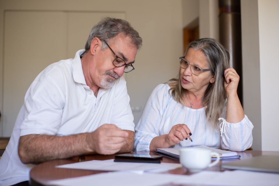 A couple at their kitchen table going through paperwork together