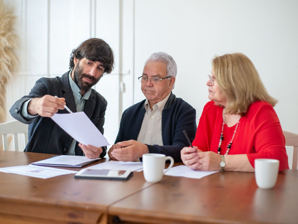 A licensed professional walking a couple through a document at a wooden table